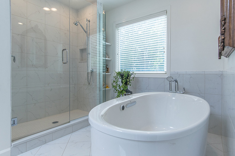 Imagen de cuarto de baño principal contemporáneo extra grande con bañera exenta, ducha abierta, baldosas y/o azulejos grises, baldosas y/o azulejos de porcelana, suelo de travertino y suelo blanco