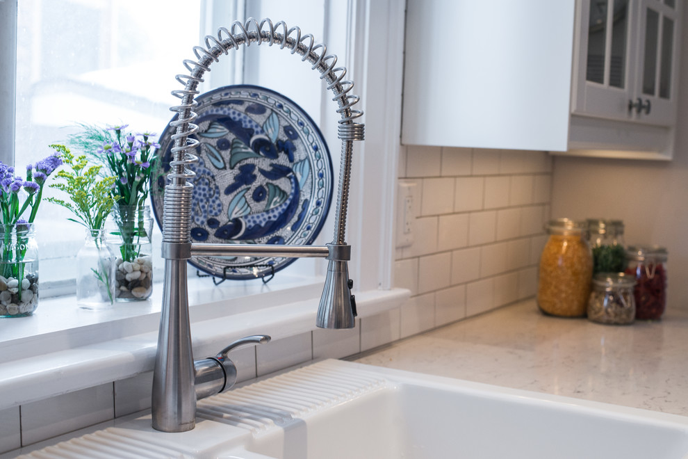Home design - transitional galley home design idea in Ottawa with recessed-panel cabinets, black cabinets, quartzite countertops, white backsplash, stainless steel appliances and no island