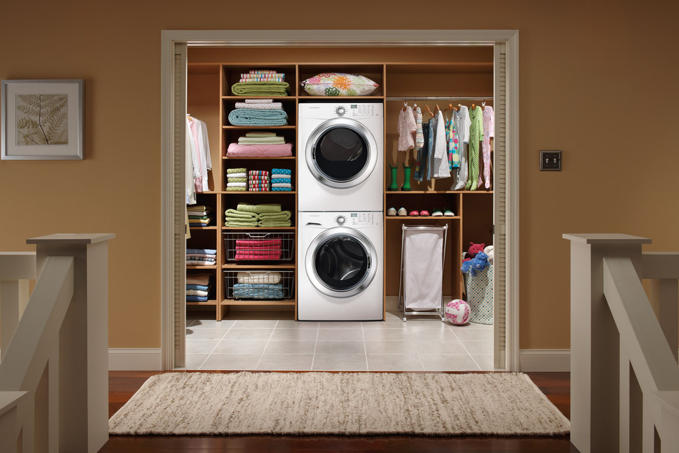 Design ideas for a small modern single-wall dedicated laundry room in New York with open cabinets, medium wood cabinets, brown walls, ceramic floors and a stacked washer and dryer.