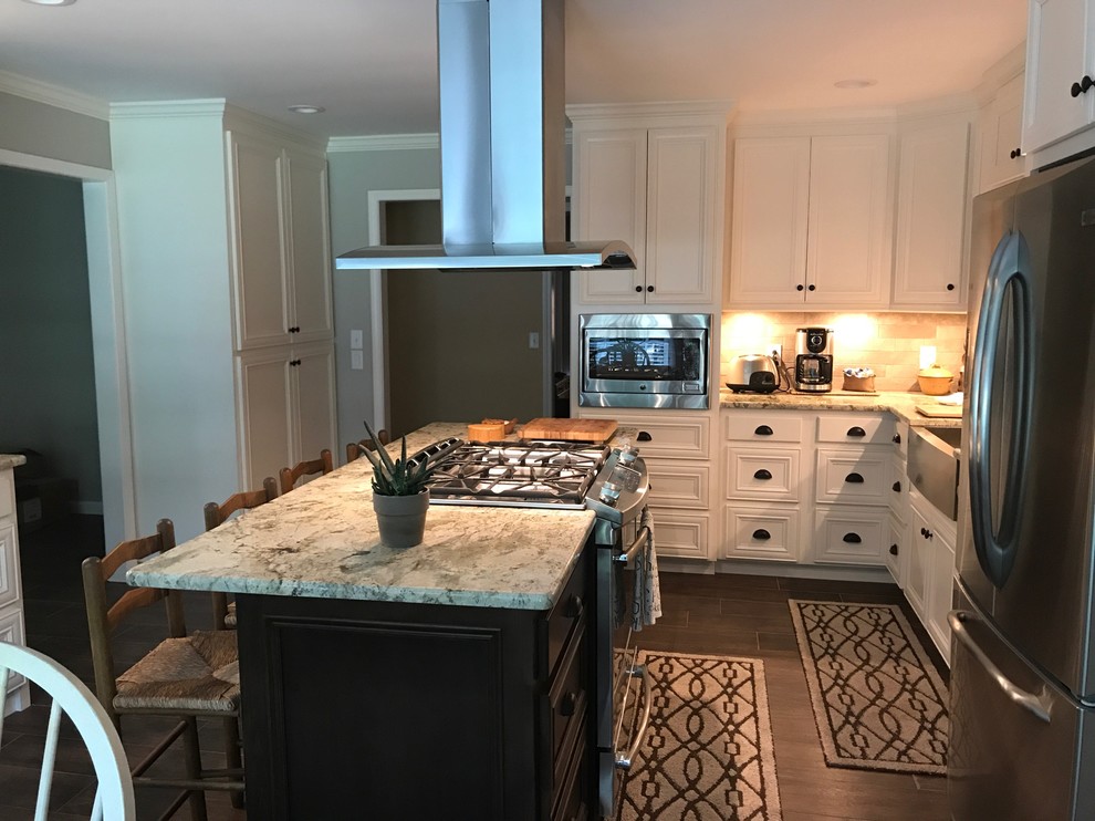 Large transitional l-shaped brown floor eat-in kitchen photo in Birmingham with a farmhouse sink, recessed-panel cabinets, white cabinets, beige backsplash, stainless steel appliances and an island