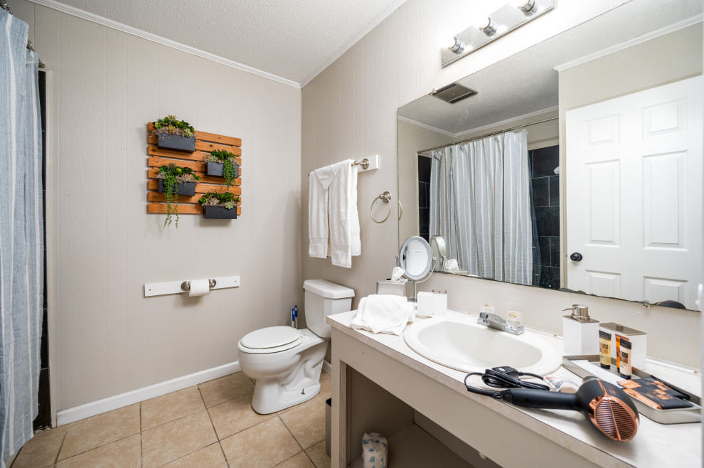 This is an example of a small romantic bathroom in New Orleans with a freestanding bath, a shower/bath combination, beige walls, porcelain flooring, beige floors, a shower curtain and a single sink.