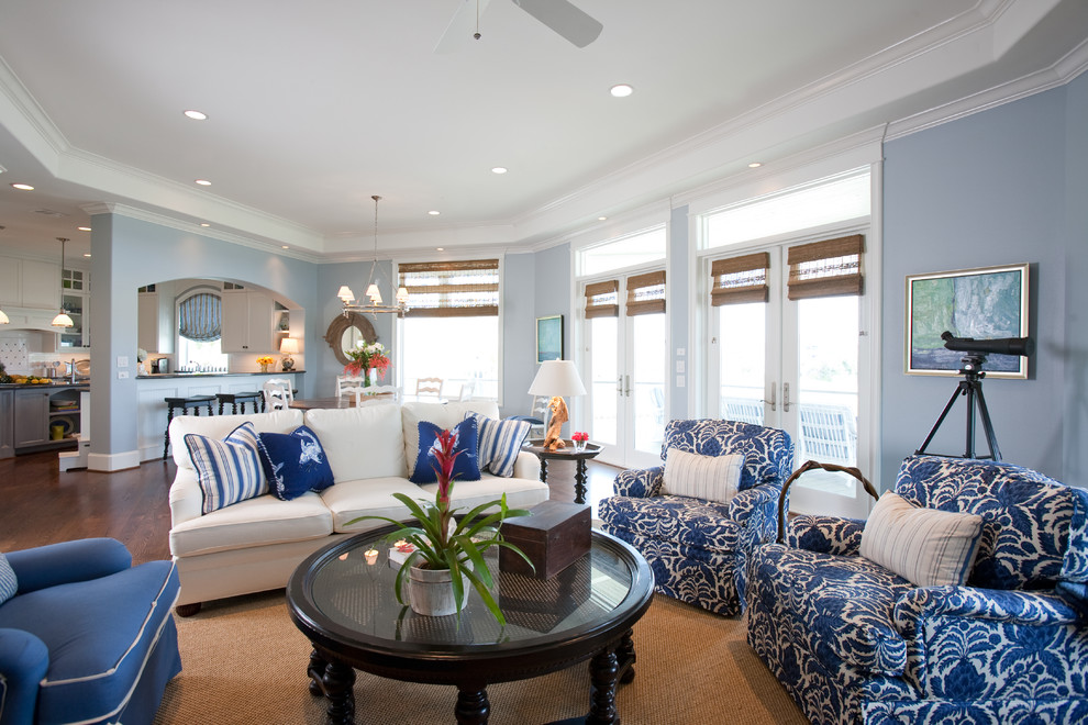Photo of a large beach style open concept living room in Houston with blue walls, dark hardwood floors, a standard fireplace, a stone fireplace surround and a wall-mounted tv.
