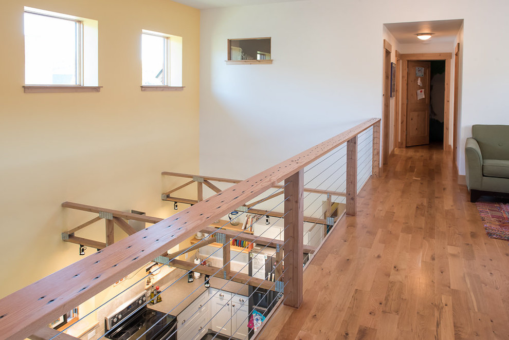 Large transitional medium tone wood floor and brown floor hallway photo with white walls