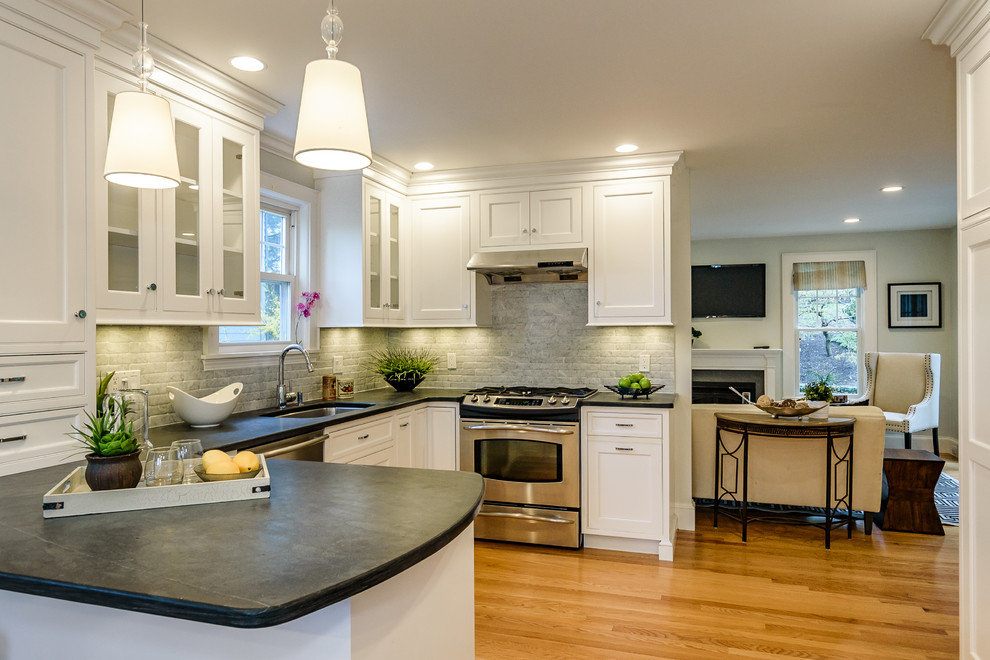 This is an example of a large contemporary u-shaped eat-in kitchen in Boston with a drop-in sink, shaker cabinets, white cabinets, concrete benchtops, grey splashback, stone tile splashback, stainless steel appliances, medium hardwood floors, a peninsula and brown floor.