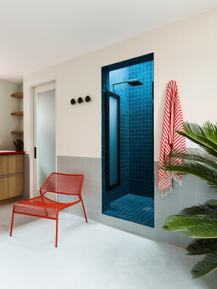 Contemporary bathroom in New York with flat-panel cabinets, medium wood cabinets, an alcove shower, gray tile, white tile, concrete floors, grey floor and red benchtops.