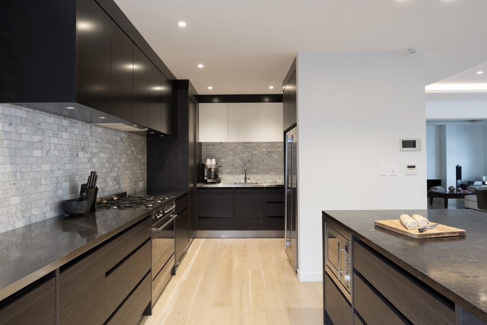 Design ideas for a large contemporary u-shaped eat-in kitchen in Auckland with an integrated sink, flat-panel cabinets, dark wood cabinets, stainless steel benchtops, grey splashback, ceramic splashback, stainless steel appliances, light hardwood floors, with island and yellow floor.