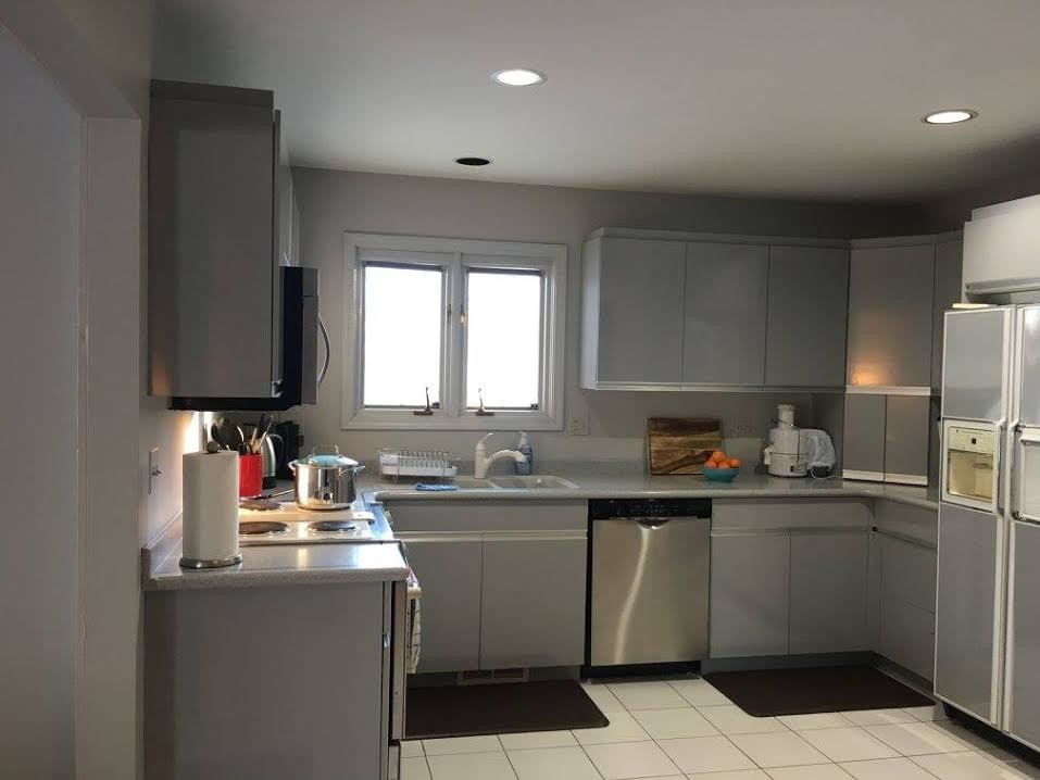 Small traditional l-shaped separate kitchen in Chicago with a double-bowl sink, flat-panel cabinets, grey cabinets, stainless steel appliances, ceramic floors, no island and white floor.