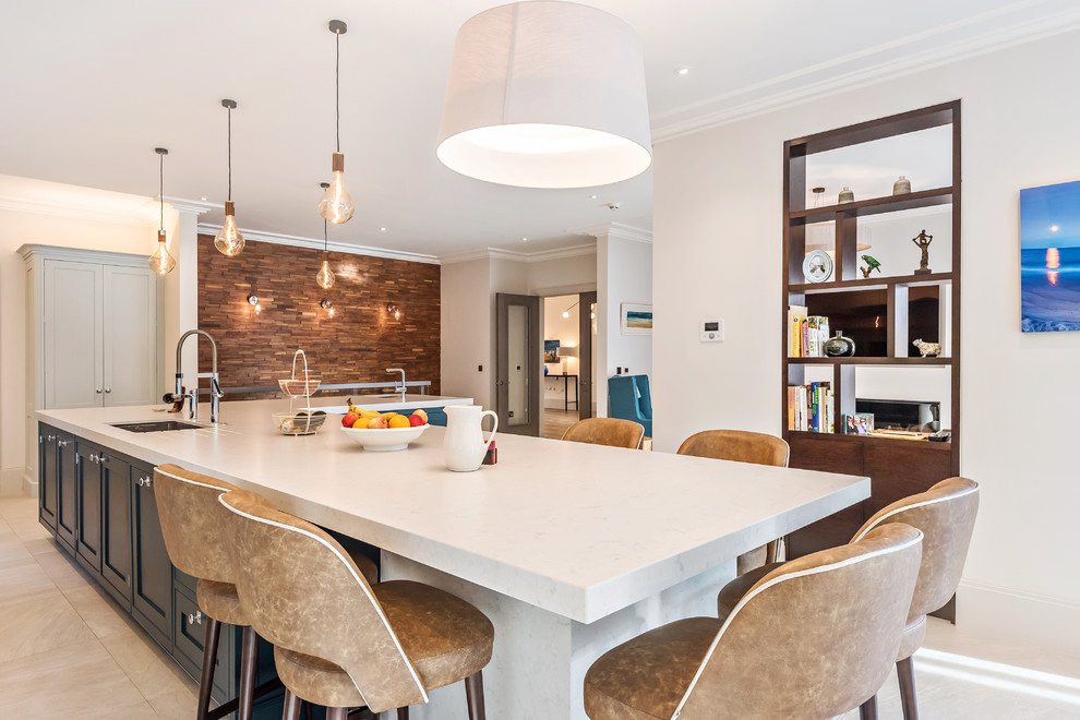 Large traditional l-shaped open plan kitchen in Berkshire with shaker cabinets, grey cabinets, quartzite benchtops, blue splashback, marble splashback, marble floors, with island, beige floor and white benchtop.