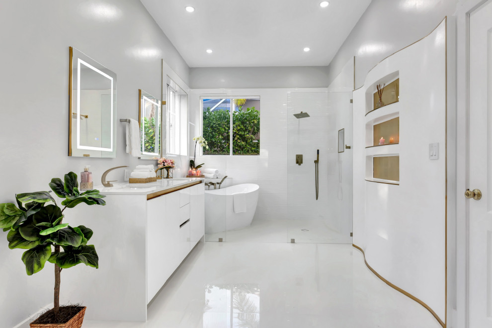 Modernes Badezimmer mit flächenbündigen Schrankfronten, weißen Schränken, freistehender Badewanne, Nasszelle, weißen Fliesen, grauer Wandfarbe, Unterbauwaschbecken, weißem Boden, offener Dusche, weißer Waschtischplatte, Doppelwaschbecken und eingebautem Waschtisch in Miami