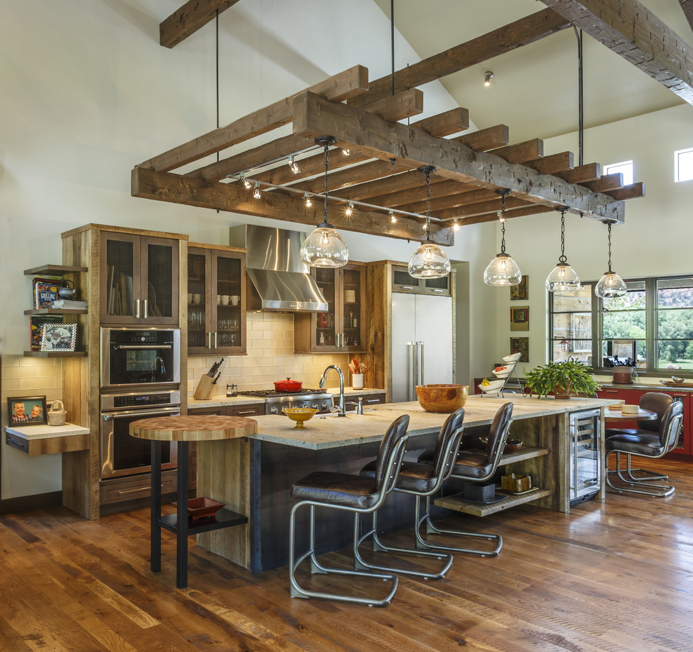 Inspiration for a rustic medium tone wood floor and brown floor eat-in kitchen remodel with glass-front cabinets, dark wood cabinets, beige backsplash, subway tile backsplash, stainless steel appliances, an island and beige countertops