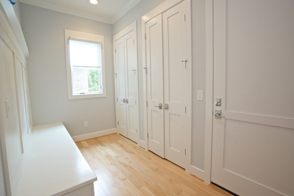 Inspiration for a large modern mudroom in Other with grey walls and light hardwood floors.