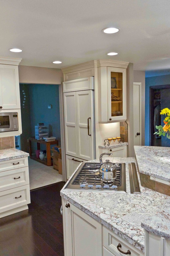Example of a large transitional galley dark wood floor eat-in kitchen design in Seattle with an undermount sink, white cabinets, granite countertops, stainless steel appliances and an island
