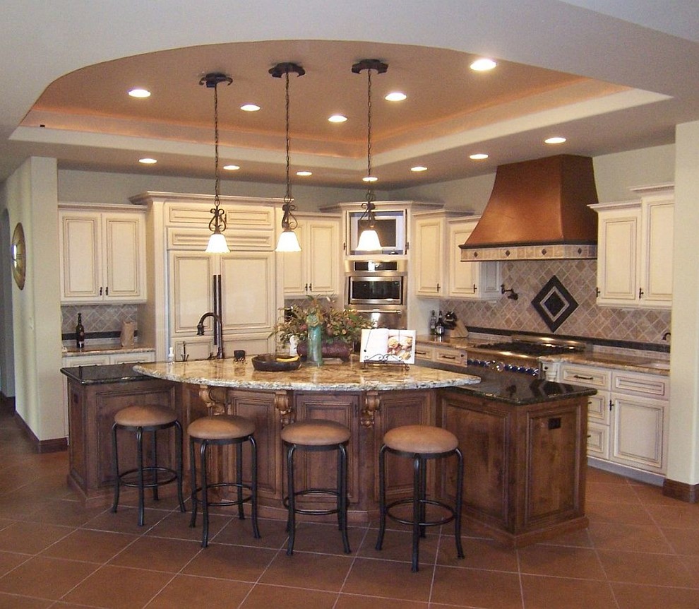 Inspiration for a large mediterranean l-shaped ceramic tile eat-in kitchen remodel with raised-panel cabinets, white cabinets, granite countertops, stone tile backsplash, stainless steel appliances and an island