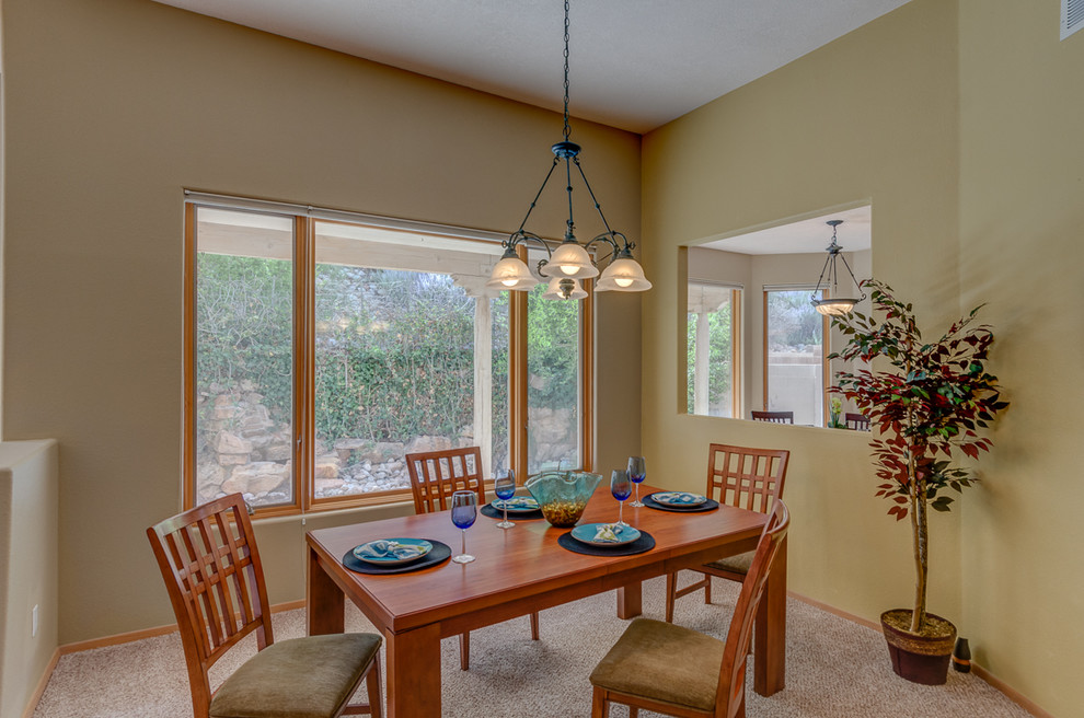 This is an example of a mid-sized open plan dining in Albuquerque with yellow walls, carpet and no fireplace.