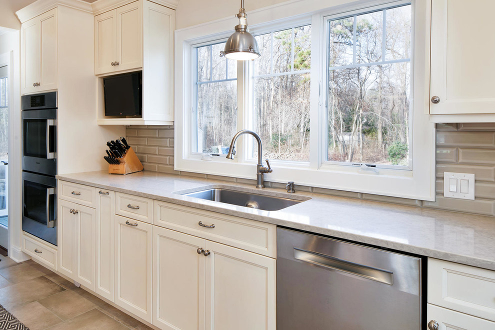 Mid-sized transitional u-shaped porcelain tile eat-in kitchen photo in New York with an undermount sink, recessed-panel cabinets, white cabinets, wood countertops, gray backsplash, subway tile backsplash, stainless steel appliances and an island