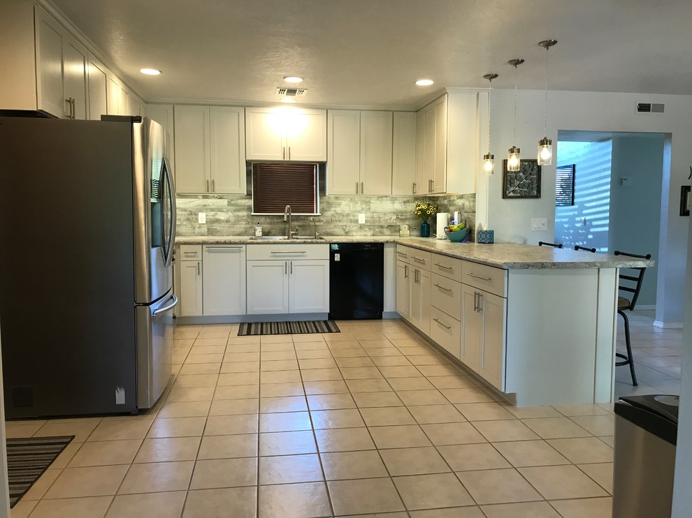 Eat-in kitchen - mid-sized transitional u-shaped ceramic tile and white floor eat-in kitchen idea in Phoenix with an undermount sink, shaker cabinets, white cabinets, granite countertops, gray backsplash, stone tile backsplash, stainless steel appliances and a peninsula