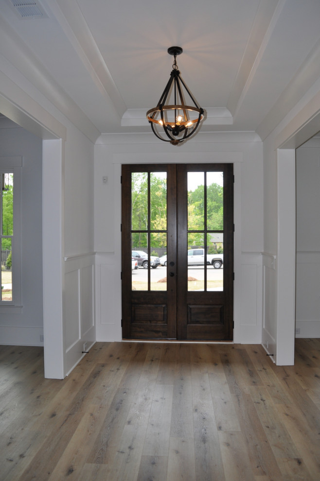 Пример оригинального дизайна: входная дверь среднего размера в стиле кантри с белыми стенами, паркетным полом среднего тона, двустворчатой входной дверью, входной дверью из темного дерева, коричневым полом и многоуровневым потолком