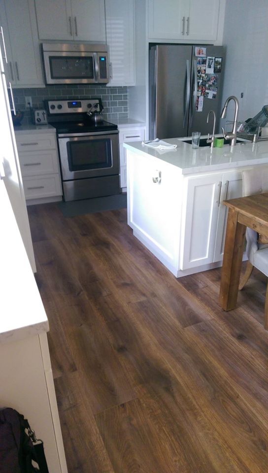 Photo of a modern kitchen in San Francisco with laminate floors and brown floor.