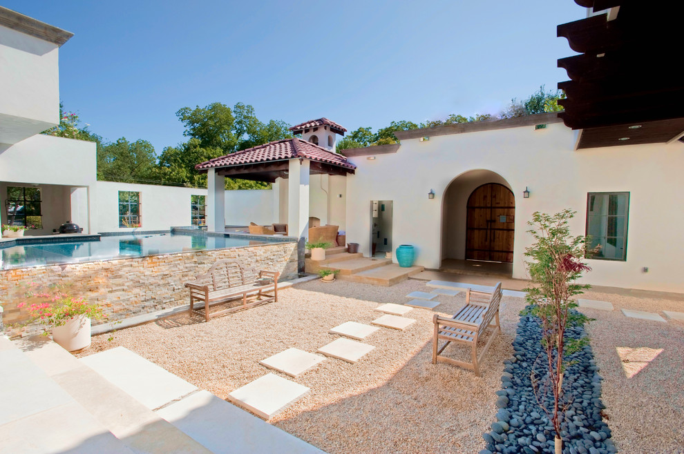 This is an example of a mediterranean patio in Austin with a gazebo/cabana and gravel.