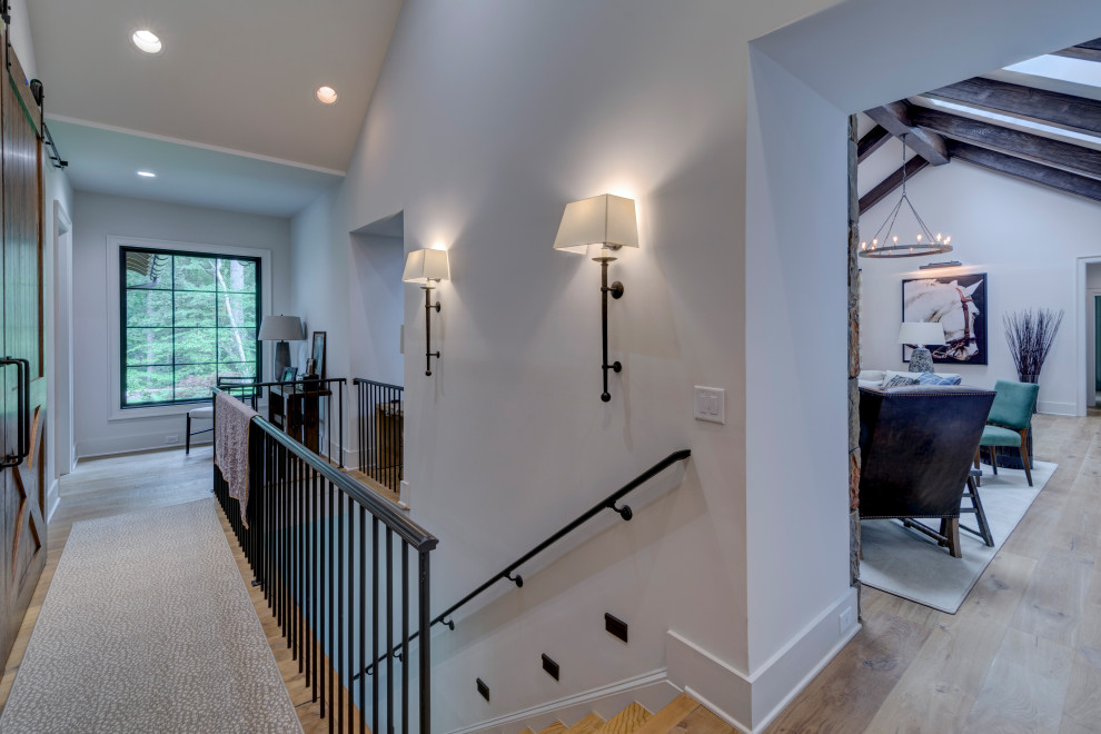 Photo of a transitional wood straight staircase in Denver with wood risers and metal railing.