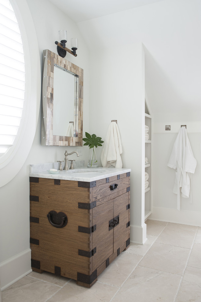 This is an example of a mid-sized beach style 3/4 bathroom in Atlanta with medium wood cabinets, white walls, an undermount sink, a two-piece toilet, light hardwood floors, marble benchtops, beige floor and flat-panel cabinets.