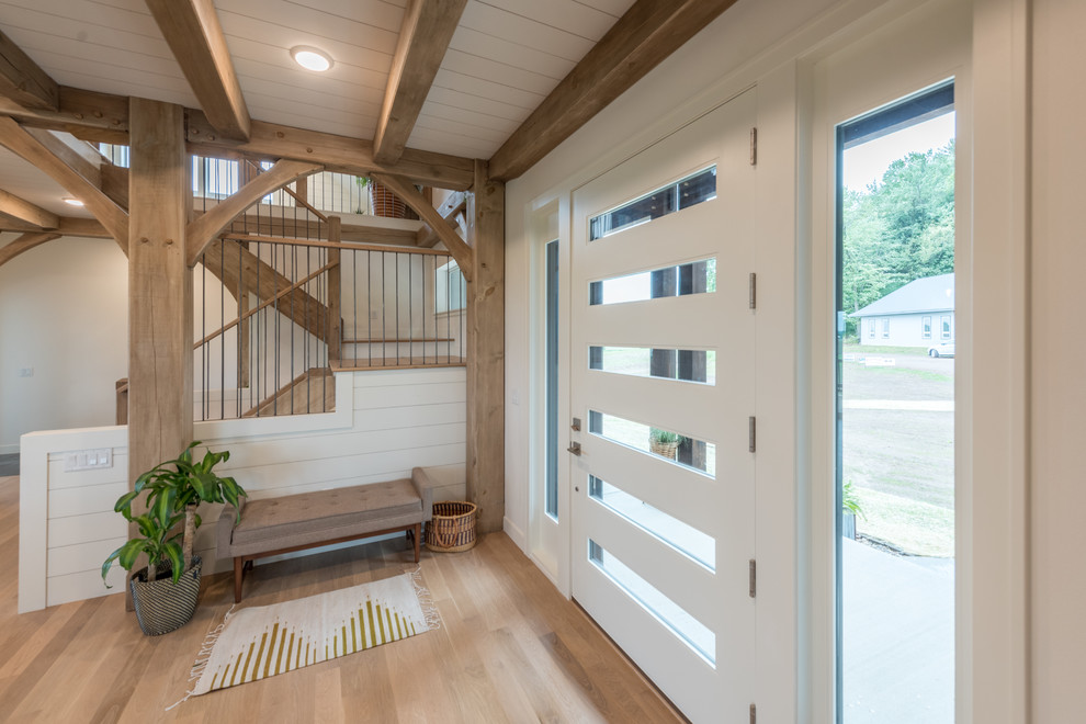 Inspiration for a mid-sized rustic light wood floor and brown floor entry hall remodel in Minneapolis with white walls and a glass front door