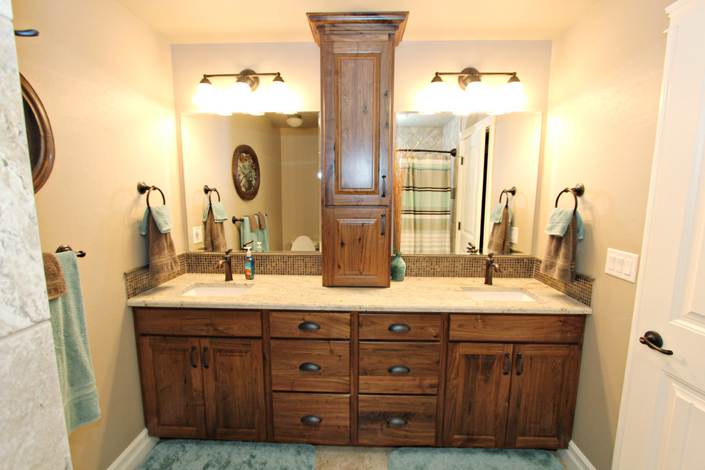 Design ideas for a mid-sized traditional 3/4 bathroom in Other with raised-panel cabinets, medium wood cabinets, a shower/bathtub combo, a two-piece toilet, brown tile, glass sheet wall, beige walls, ceramic floors, an undermount sink, granite benchtops, beige floor and a shower curtain.