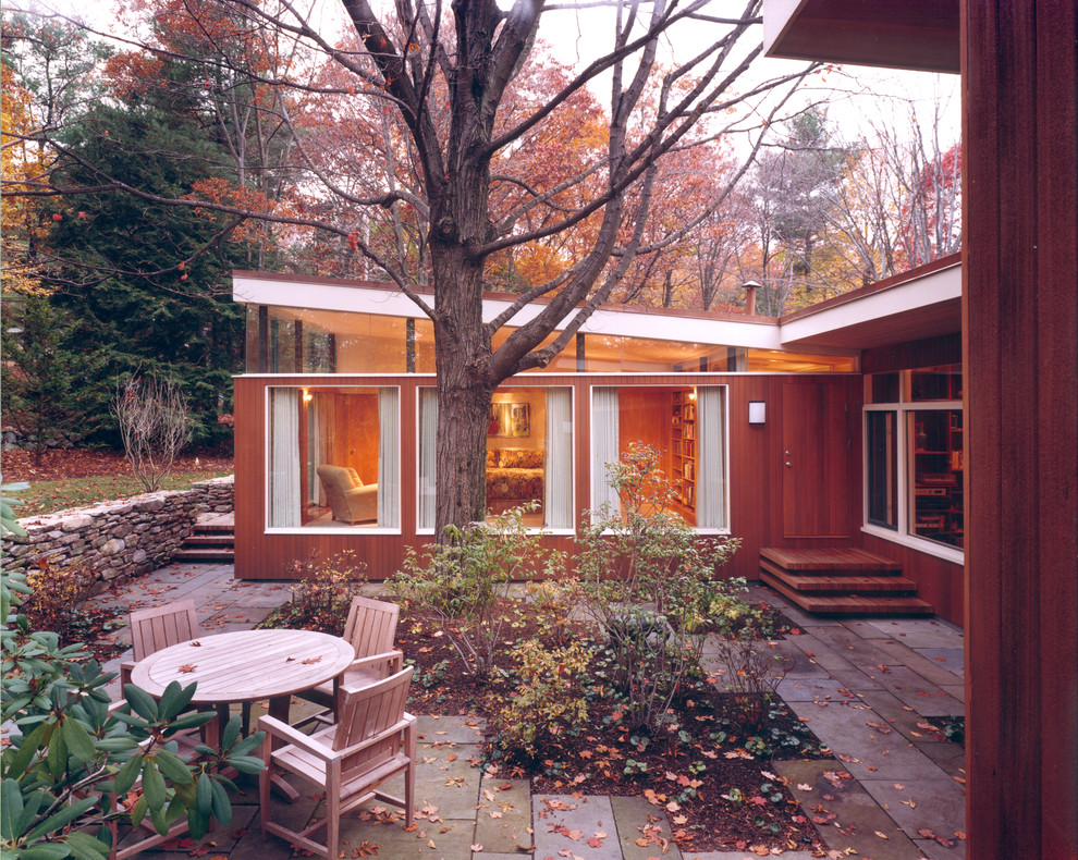 This is an example of a mid-sized modern one-storey brown exterior in Boston with wood siding and a flat roof.