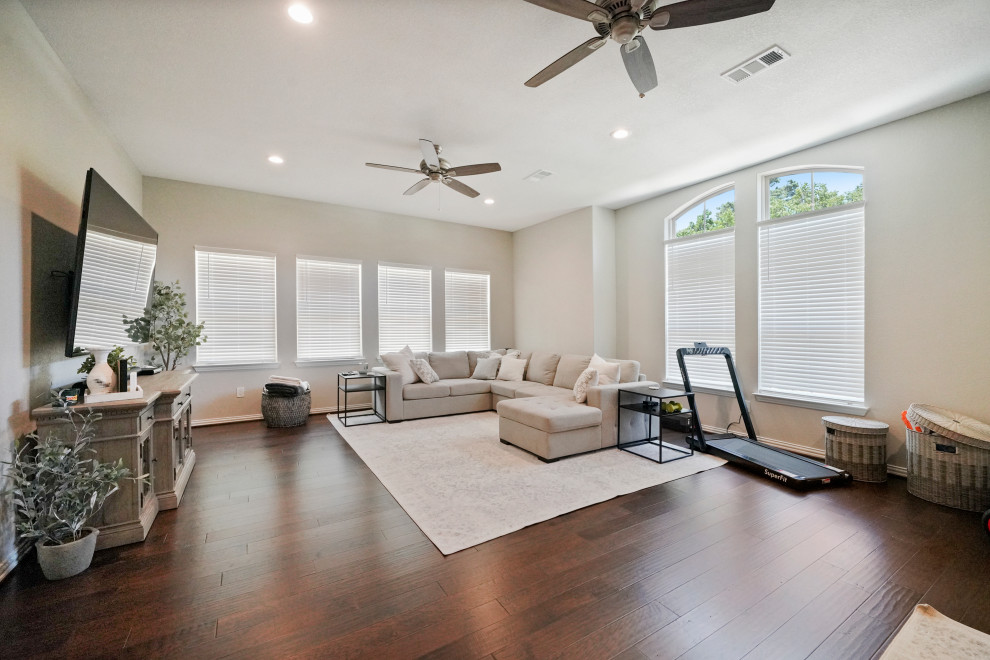 Medium sized contemporary open plan living room in Houston with dark hardwood flooring.