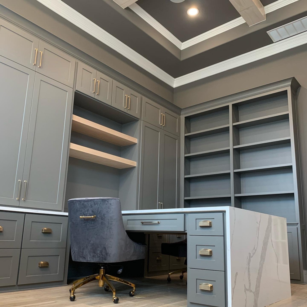 Example of a mid-sized transitional built-in desk medium tone wood floor, brown floor and coffered ceiling home studio design in Dallas with gray walls