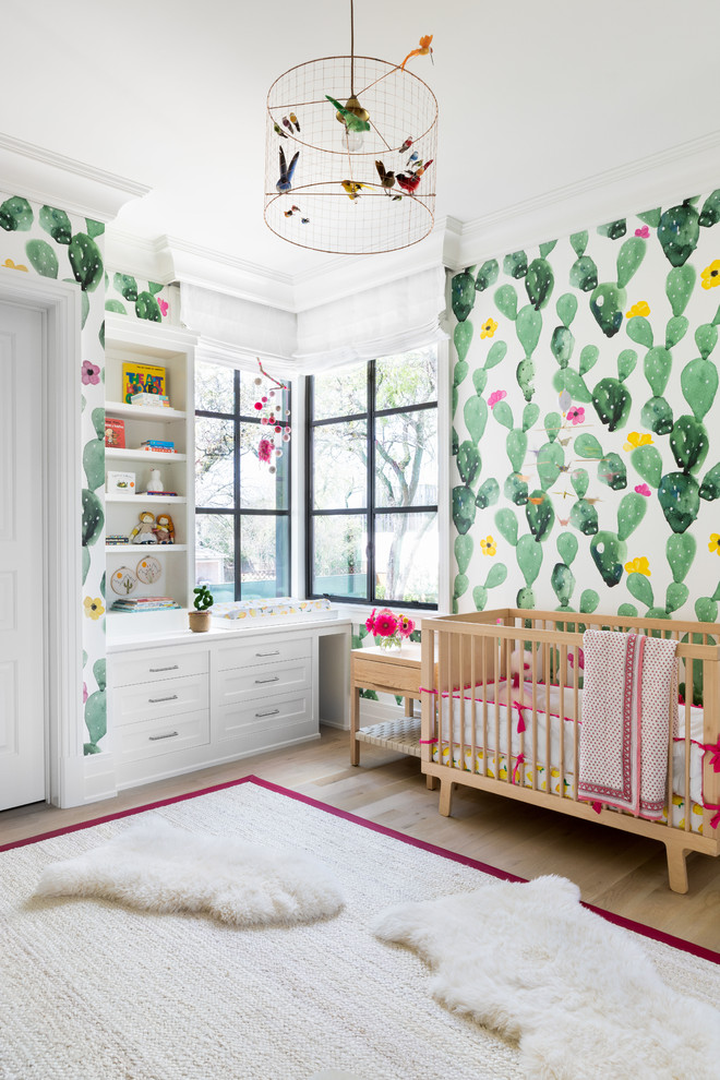 This is an example of a large transitional nursery for girls in Austin with light hardwood floors and multi-coloured walls.