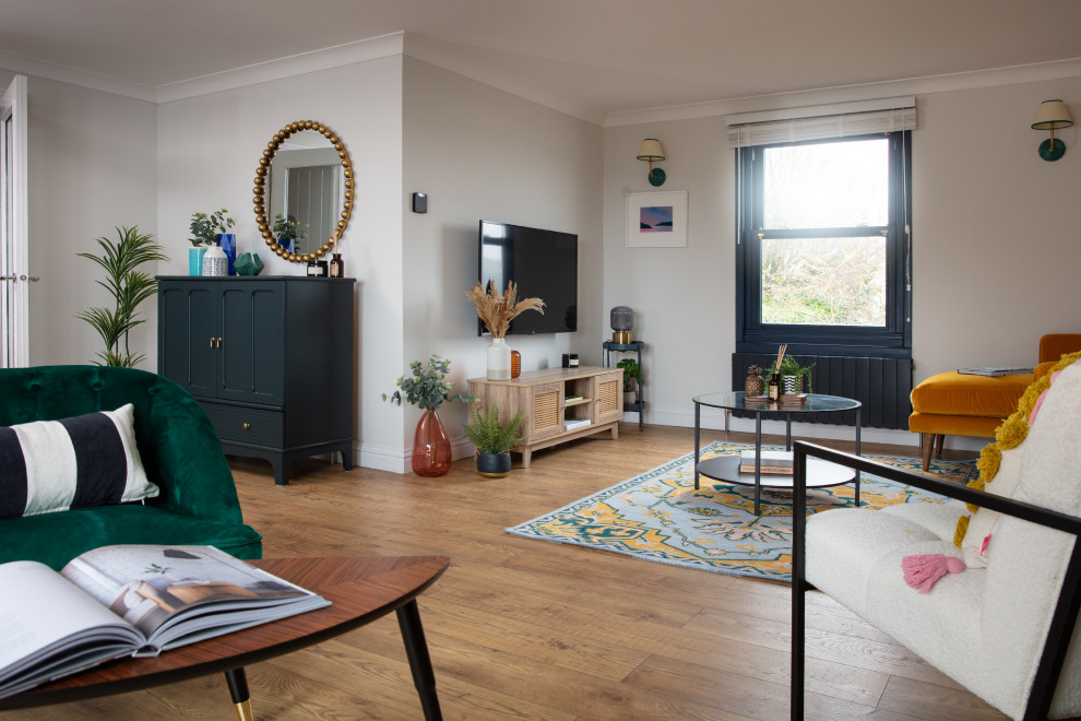 Mittelgroßes, Repräsentatives, Offenes Eklektisches Wohnzimmer ohne Kamin mit grauer Wandfarbe, braunem Holzboden, TV-Wand und braunem Boden in Cornwall