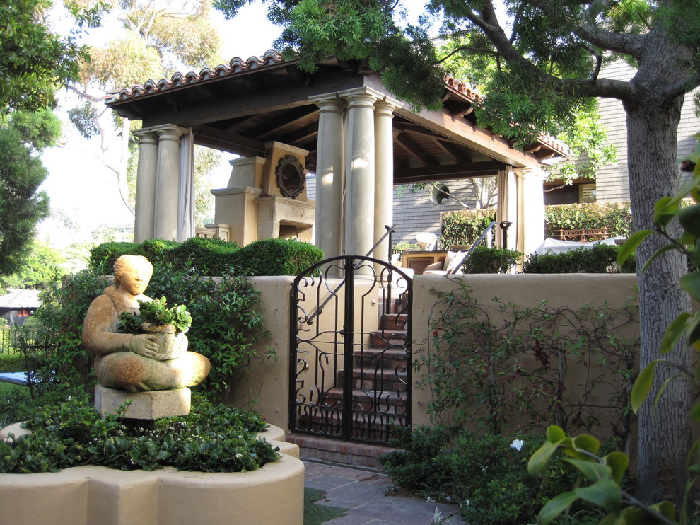 Design ideas for a mediterranean backyard patio in San Diego with natural stone pavers and with fireplace.