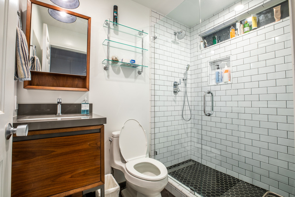 Photo of a mid-sized contemporary 3/4 bathroom in San Francisco with louvered cabinets, distressed cabinets, an alcove shower, a one-piece toilet, white tile, subway tile, white walls, cement tiles, an undermount sink, granite benchtops, a hinged shower door and grey benchtops.