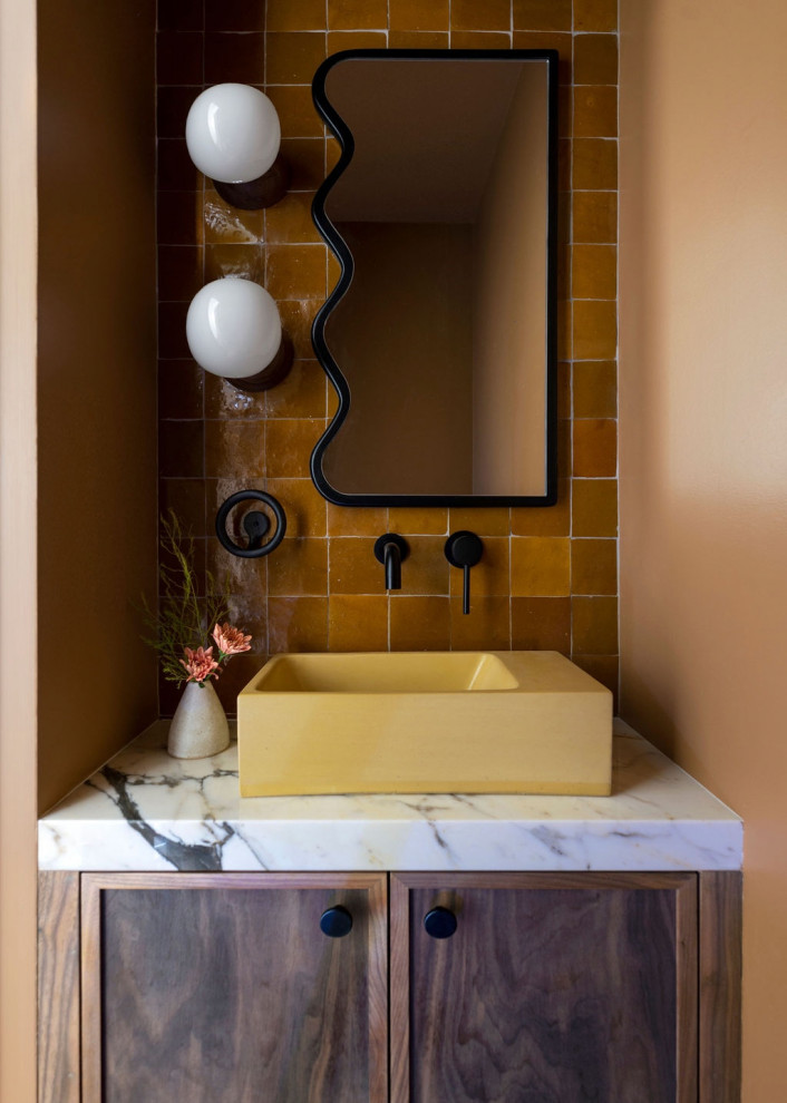Small midcentury powder room in San Francisco with shaker cabinets, dark wood cabinets, a wall-mount toilet, brown tile, cement tile, brown walls, ceramic floors, a vessel sink, marble benchtops, grey floor, white benchtops and a floating vanity.