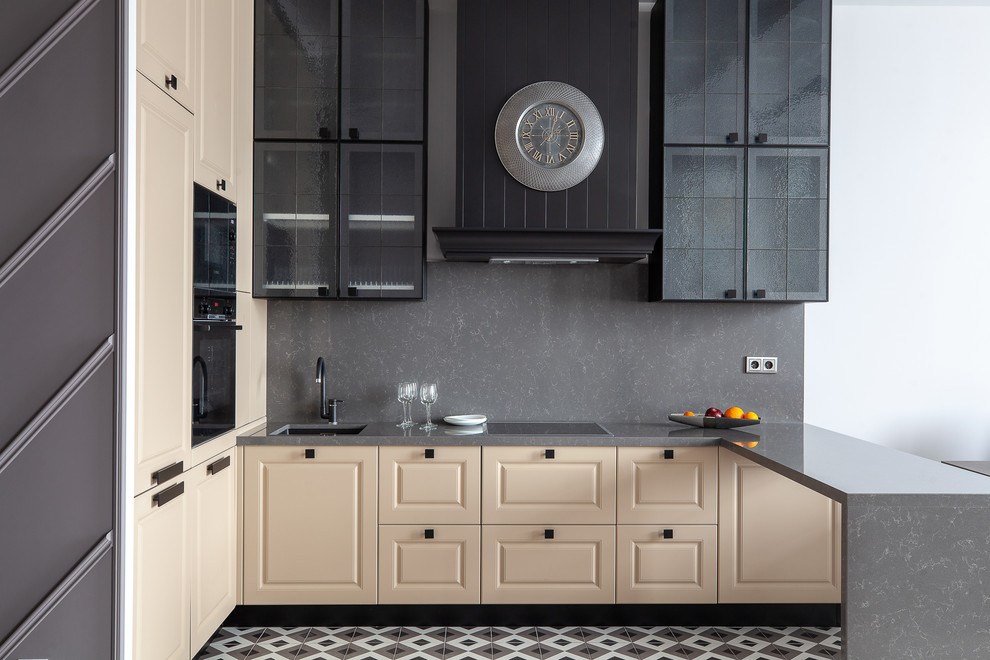 Inspiration for a mid-sized transitional kitchen in Moscow with an undermount sink, raised-panel cabinets, beige cabinets, quartz benchtops, grey splashback, stone slab splashback, black appliances, ceramic floors, grey benchtop, a peninsula and multi-coloured floor.