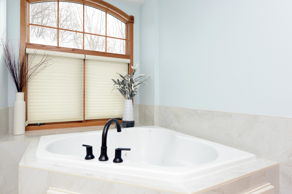 Mid-sized transitional master white tile and stone tile porcelain tile and white floor corner bathtub photo with shaker cabinets, white cabinets, a one-piece toilet, blue walls, an integrated sink, solid surface countertops, a hinged shower door and white countertops