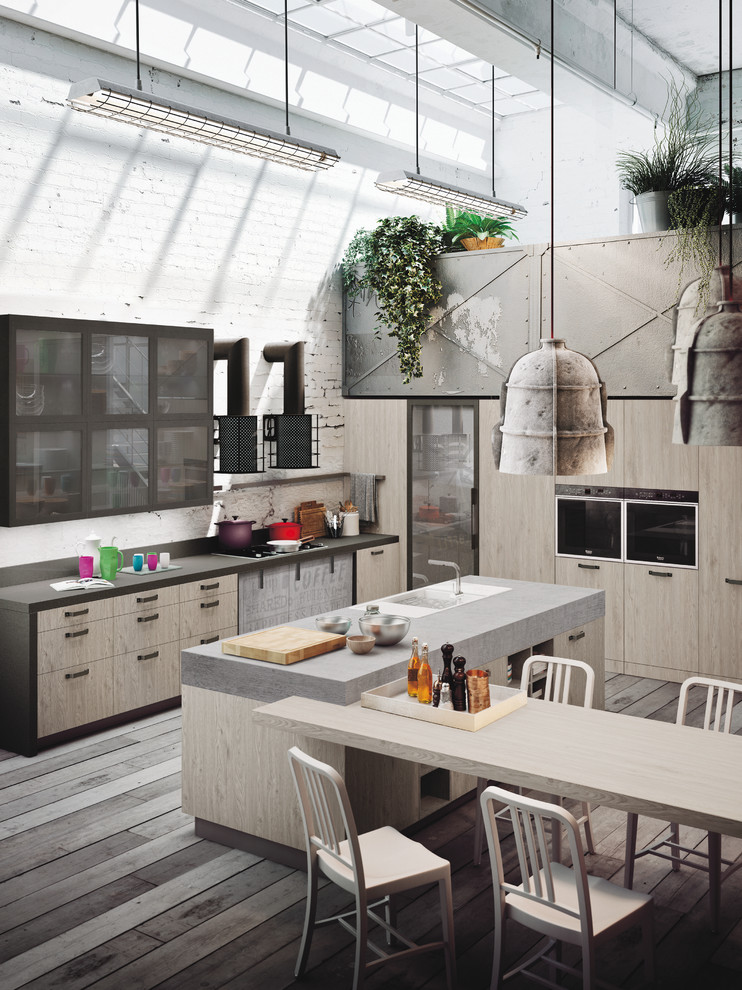Mid-sized industrial l-shaped open plan kitchen in Marseille with an integrated sink, glass-front cabinets, light wood cabinets, concrete benchtops, grey splashback, cement tile splashback, black appliances, painted wood floors and with island.