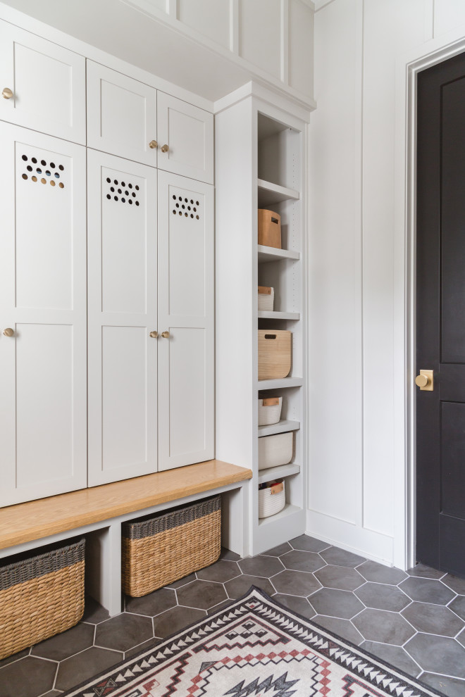 Design ideas for a scandinavian mudroom in Chicago with white walls, grey floor and panelled walls.