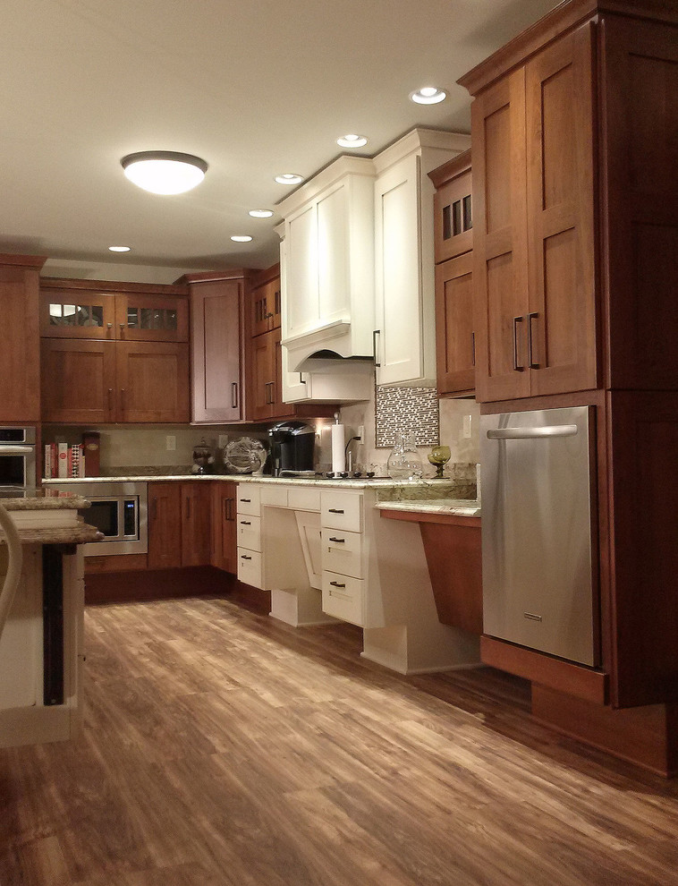 Example of a large transitional l-shaped medium tone wood floor open concept kitchen design with an undermount sink, shaker cabinets, medium tone wood cabinets, granite countertops, beige backsplash, ceramic backsplash, white appliances and an island