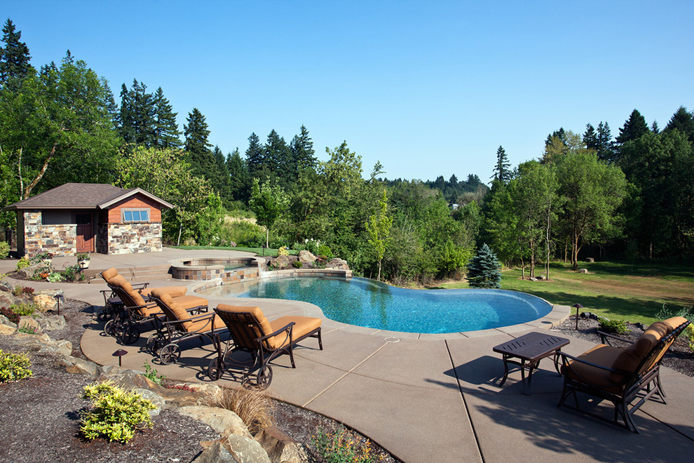 Contemporary custom-shaped pool in Portland with concrete slab.