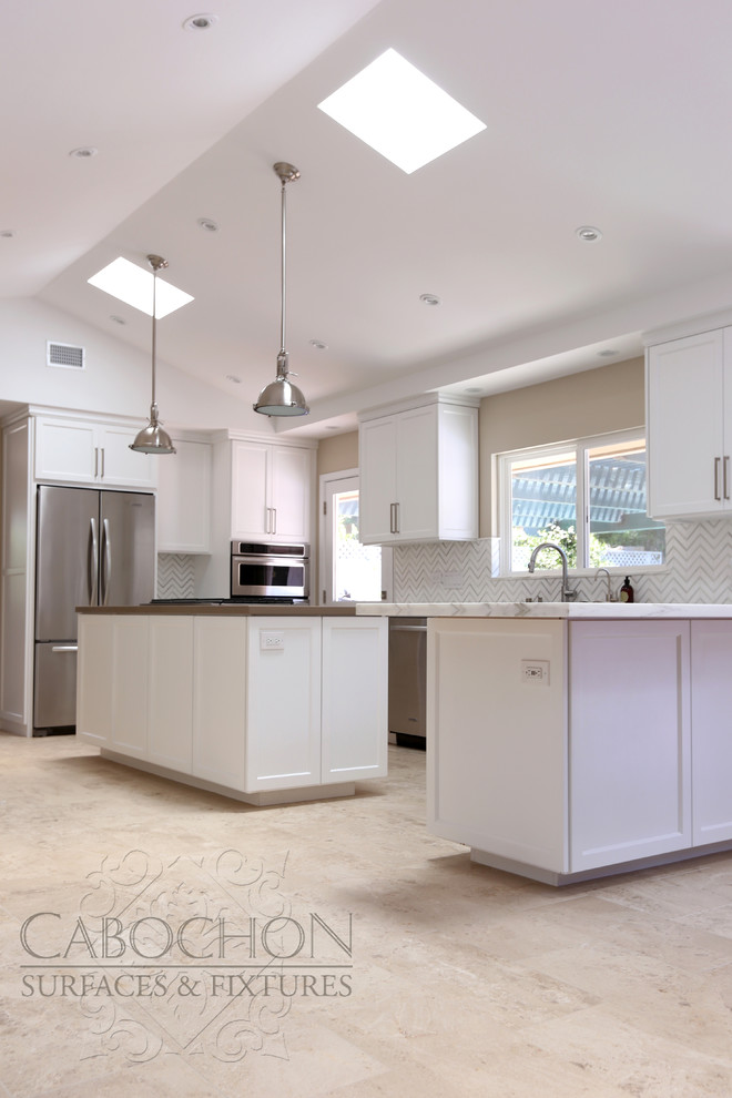 Mid-sized transitional l-shaped limestone floor open concept kitchen photo in San Diego with an island, shaker cabinets, white cabinets, marble countertops, white backsplash, mosaic tile backsplash, stainless steel appliances, an undermount sink and beige walls
