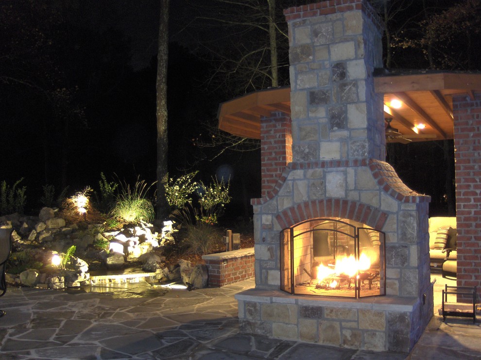 Photo of a large traditional backyard patio in Atlanta with a fire feature, natural stone pavers and a pergola.