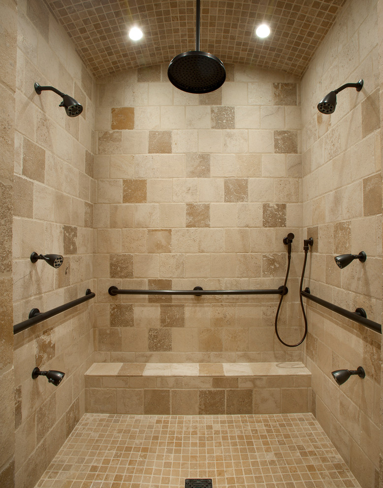 Mid-sized mediterranean master bathroom in Phoenix with beige tile, stone tile, an alcove shower, beige walls, limestone floors, raised-panel cabinets, dark wood cabinets, an undermount tub, a one-piece toilet, an undermount sink and limestone benchtops.
