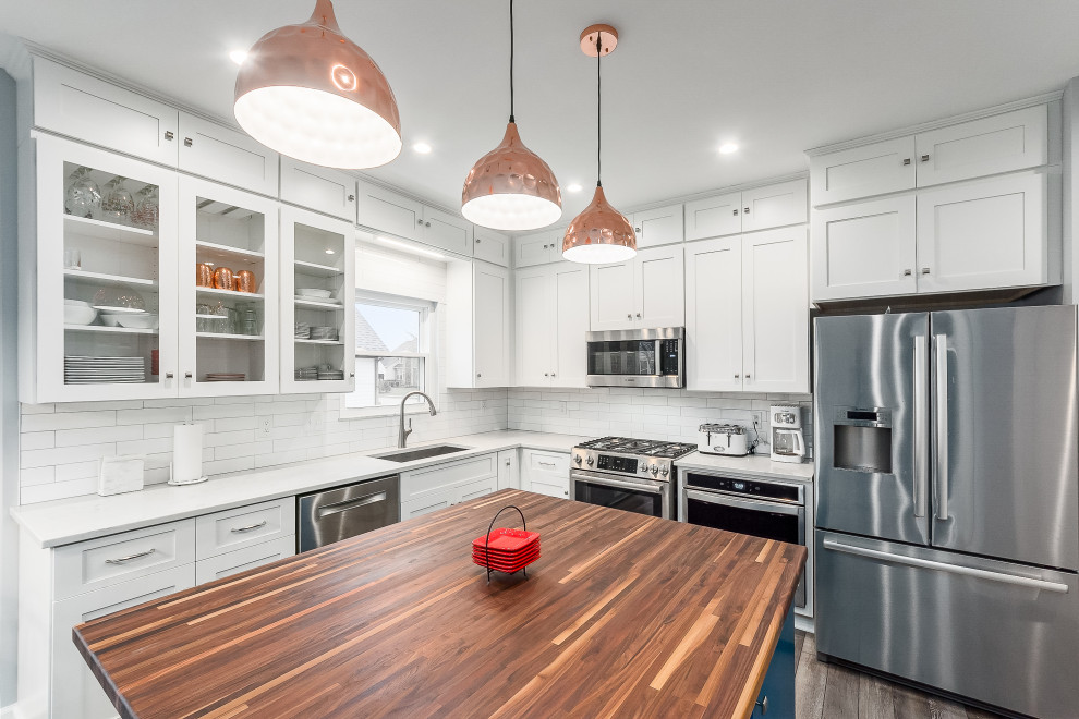 Mid-sized transitional l-shaped eat-in kitchen photo in Columbus with shaker cabinets, quartz countertops, white backsplash, subway tile backsplash and an island