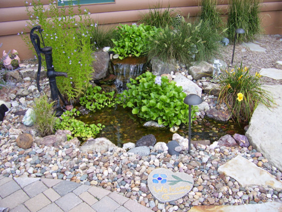 Photo of a traditional side yard full sun garden for summer in Kansas City with a water feature and natural stone pavers.