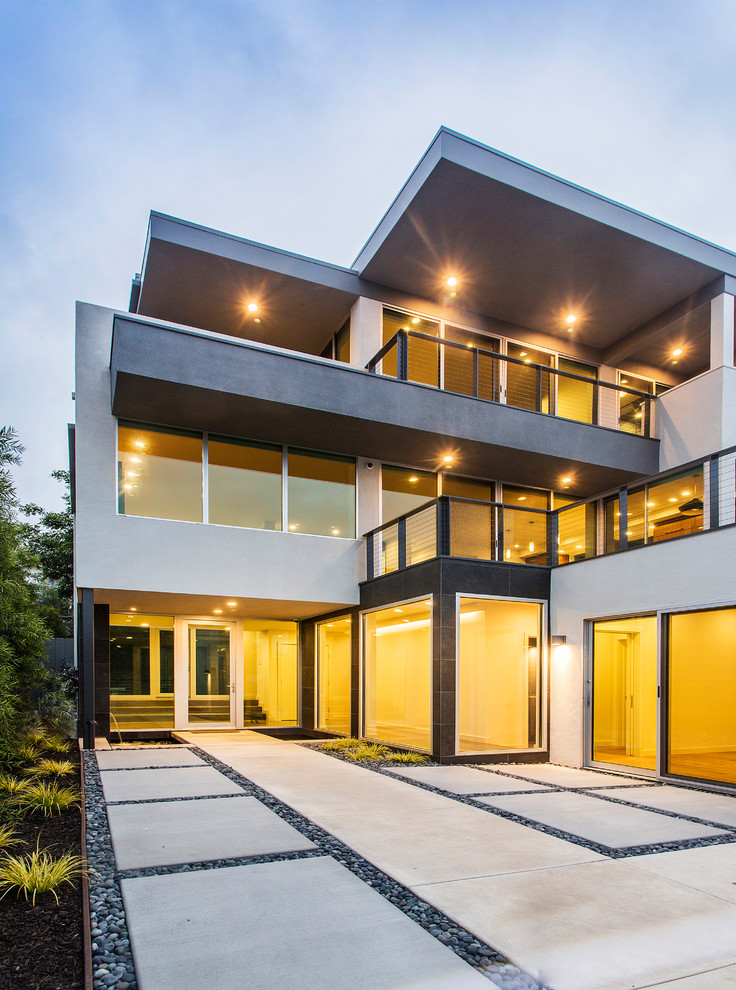Large contemporary three-storey stucco grey house exterior in San Diego.
