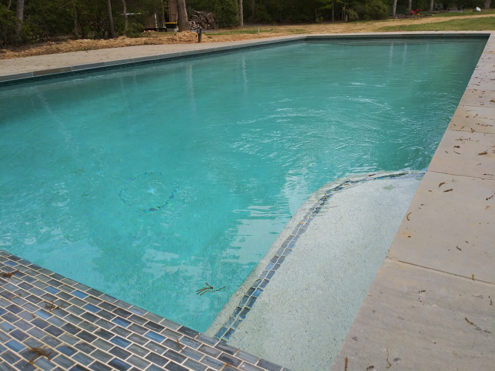 Aménagement d'une piscine arrière moderne de taille moyenne et rectangle avec une dalle de béton.