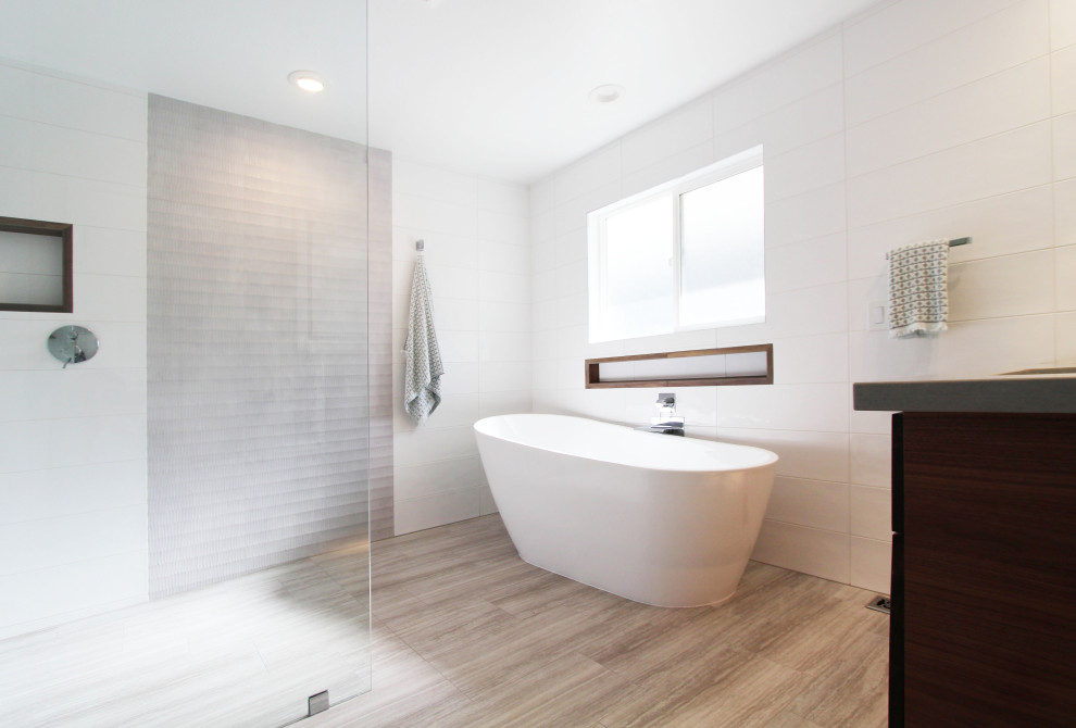 Example of a large transitional master white tile and ceramic tile porcelain tile, gray floor and double-sink freestanding bathtub design with flat-panel cabinets, dark wood cabinets, a one-piece toilet, white walls, an undermount sink, quartz countertops, gray countertops, a niche and a floating vanity