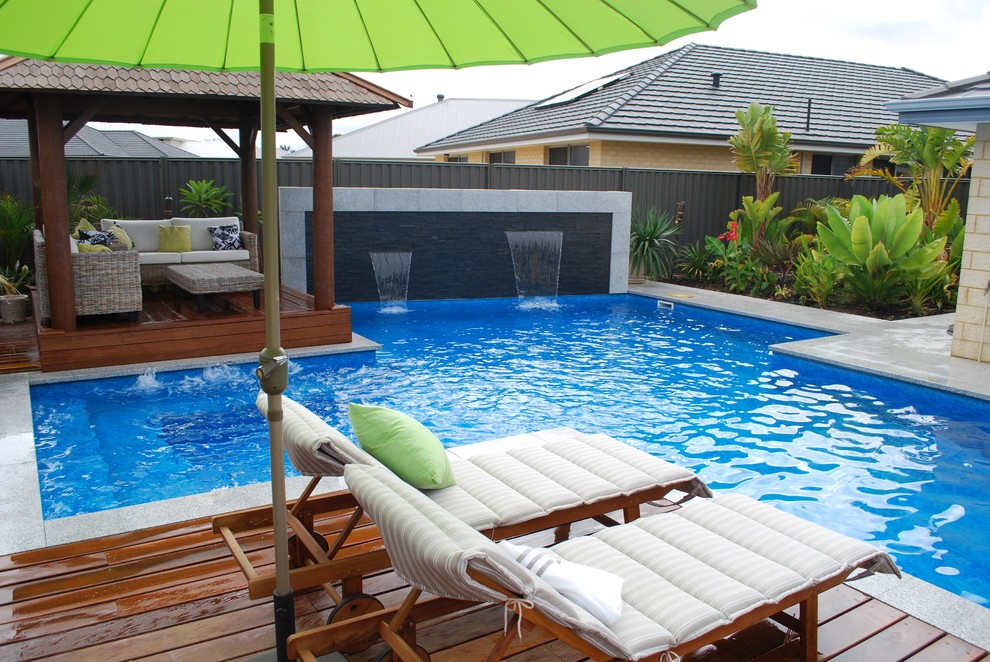 Photo of a large modern backyard custom-shaped pool in Perth with tile.